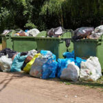 Tech Giants Shake Up Trash Collection Overflowing garbage bins with bags on the ground.