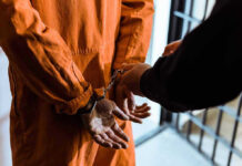 Shocking Error Jails Innocent Dad — Misses Childbirth Handcuffed person in orange jumpsuit being escorted