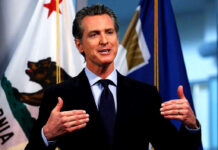 Newsom X Post SPARKS Secret Service Alarm Man speaking with flags in the background