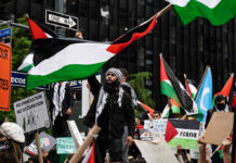 Hamas Victory? Western Shift Stuns Everyone Protesters with flags and signs, one holding a megaphone
