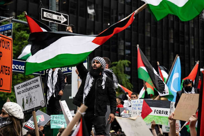 1973000603 Protesters with flags and signs, one holding a megaphone
