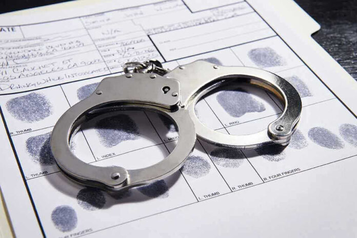 608376650 Handcuffs on fingerprint form with fingerprints visible