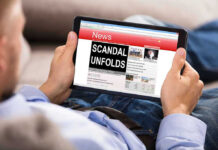 Person reading tablet with headline Scandal Unfolds