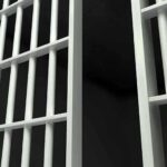 27-Year Injustice ENDS: Shocking Confession Revealed Close up view of metal prison bars in a dark environment