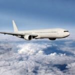 Airline Apology FURY: Privacy Violated at 30,000 Feet A white airplane flying above fluffy clouds in a blue sky