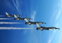 Russian Fighter Jets Ignite NATO Panic Four military jets flying in formation against a blue sky, leaving smoke trails
