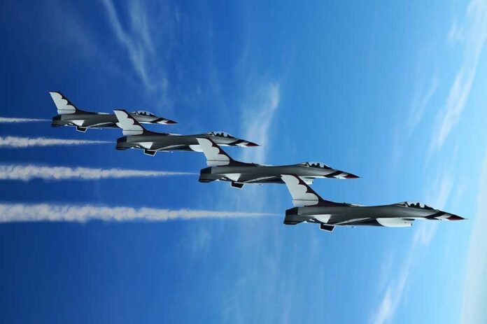 shutterstock_39456169.jpg Four military jets flying in formation against a blue sky, leaving smoke trails