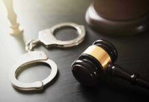 Gavel and handcuffs on a dark surface