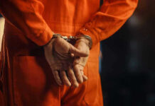 Arrest Shocker: Florida Man’s Wild 26th Bust Person in orange jumpsuit with handcuffs behind back