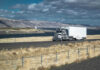 $160 Million Funding Threat—State on the Brink Truck driving on rural highway near river and mountains