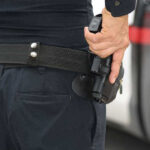Person holding a gun in a holster