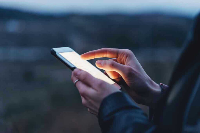 585973055 Person using a smartphone at dusk