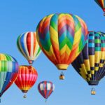 Balloons Invade! Smugglers Ground Airport Colorful hot air balloons floating in a clear blue sky