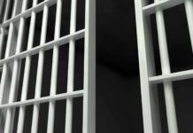 Supermax Drama Unfolds – ACLU Fights Trump’s Move Close up view of metal prison bars in a dark environment