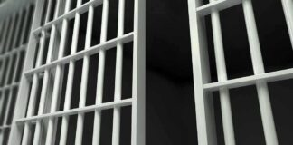 Close up view of metal prison bars in a dark environment