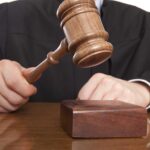 Death Penalty Dropped—DOJ Faces Backlash A judge holding a gavel above a wooden block