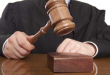 Death Penalty Dropped—DOJ Faces Backlash A judge holding a gavel above a wooden block