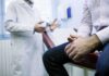 Doctor ESCAPES Punishment — Crosses State Lines A doctor in a white coat discussing with a patient sitting on an examination table