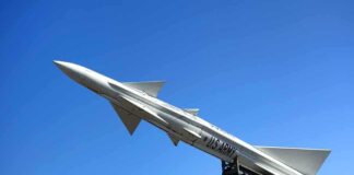 A military missile pointed upwards against a clear blue sky