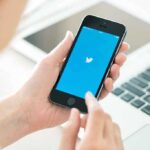 Elon Musk Triggers Mass Twitter Lockouts Person holding a smartphone displaying the Twitter app