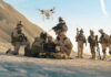 Soldiers operating a drone in a desert environment