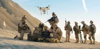 Soldiers operating a drone in a desert environment