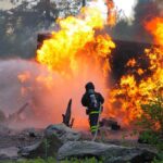 Aide ARRESTED After Raleigh Blaze—Two People INSIDE! Firefighter battling a large fire with water spray