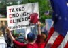Radical Tax Plan TARGETS White Neighborhoods Protesters holding signs against taxation at a political demonstration
