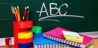 A collection of colorful school supplies including notebooks, pens, and scissors on a desk