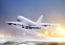 An airplane taking off from an airport runway against a twilight sky