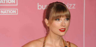 Woman with red lipstick in front of pink background.