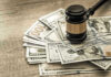 Gavel on a pile of hundred-dollar bills.