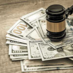 Gavel on a pile of hundred-dollar bills.