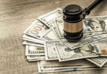 HR Giant SHOCKED by Massive Discrimination Fine Gavel on a pile of hundred-dollar bills.