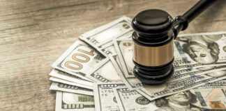 Gavel on a pile of hundred-dollar bills.