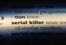 Close-up of a dictionary page showing the definition of 'serial killer'