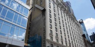 Facade of the Paramount Hotel alongside modern buildings under construction