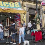 A bustling taco stand with people enjoying street food