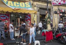 Taco Chain CRUSHED by ICE Raids A bustling taco stand with people enjoying street food