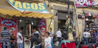 A bustling taco stand with people enjoying street food