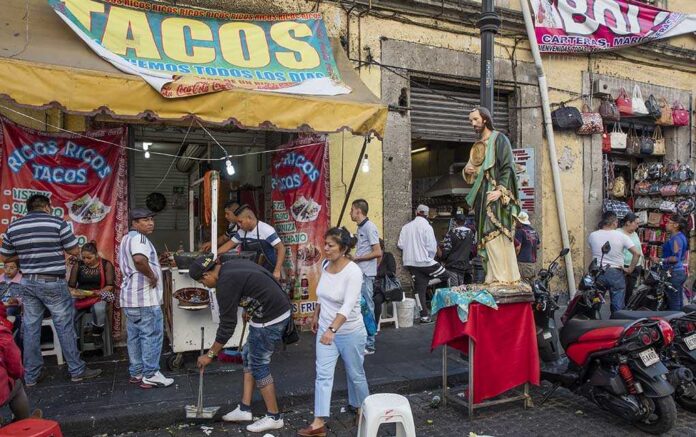 A bustling taco stand with people enjoying street food