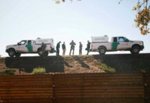 NOTORIOUS Cartel Leader’s Brutal Reign Ends Border Patrol vehicles and agents on a ridge.
