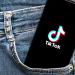 AI Influencer DUPES Millions – TikTok’s BIGGEST Scandal Phone with TikTok logo in jeans pocket.