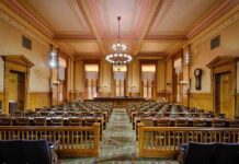 Look Who Maduro HIRED!—U.S. Court Drama Unfolds Interior view of a historic courtroom with wooden furnishings and chandeliers