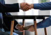 Handshake and exchange of money under the table.