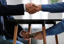 Handshake and exchange of money under the table.