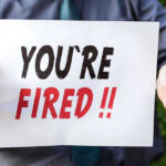 EMBARRASSING Removal Rocks Trump Justice Department Person holding YOURE FIRED sign.