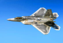 Fighter jet in flight against a clear blue sky.