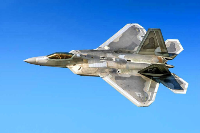 Fighter jet in flight against a clear blue sky.