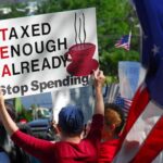 Protesters holding signs against taxation at a political demonstration